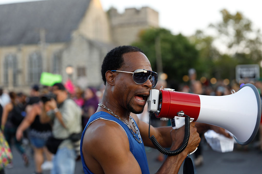 A protest leader organizes the crowd while marching